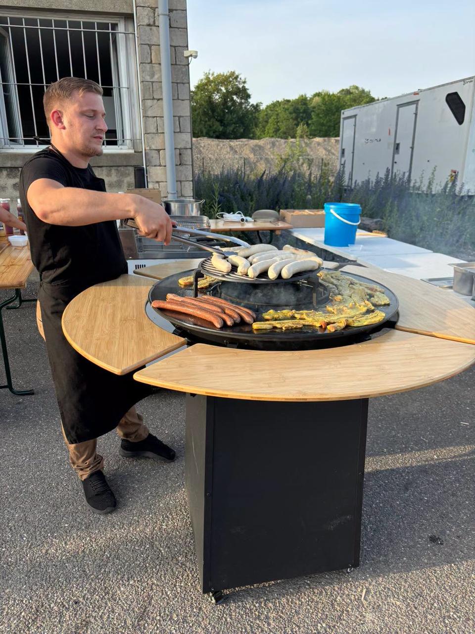 Chef Oh Grill grillant viandes et poissons au feu de bois devant les convives